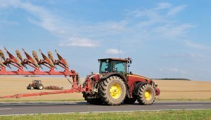 Tractor moving plough on the road