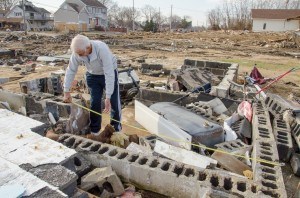 Morris Tetro, Hurricane Sandy survivor, measures the foundation of his daughter's house for replacement cost estimates. Photo by Liz Roll/FEMA 