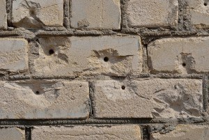 brick wall with bullet holes