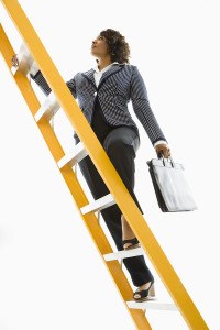 Businesswoman climbing ladder.