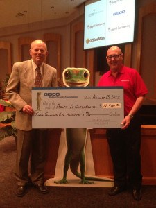 GEICO's Field Representative Jim Whitten (left) presents check to Bob Thacker (right), executive director of AdoptAClassroom.org. (Photo: Business Wire) 