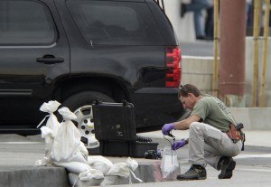 A Los Angeles FBI investigator collects evidence after a device worn by a bank manager was rendered safe by a bomb squad outside a Bank of America branch in East Los Angeles Wednesday, Sept. 5, 2012. (AP Photo/Damian Dovarganes)