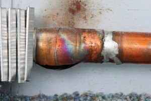 closeup image of a frozen and broken copper radiator pipe