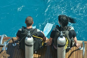 Two scuba divers preparing to dive into sea