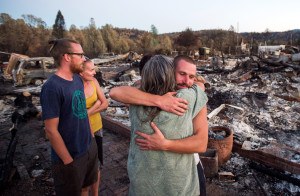 Charlie Liethen, right, embraces Sharon Dawson, who lost her home in a wildfire, in Middletown, Calif., Monday, Sept. 21, 2015. Gov. Jerry Brown requested a presidential disaster declaration on Monday, noting that more than 1,000 homes had been confirmed destroyed, with the number likely to go higher as assessment continues. (AP Photo/Noah Berger)