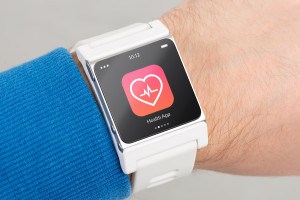 Close up white smart watch with health app icon on the screen is on hand