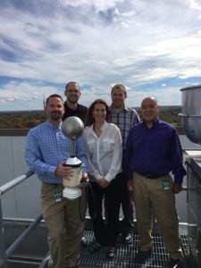 Amica employees Adam Kostecki (from left), Brian Leroux and Larry Brown (far right) with Nicole Homeier, vice president of Understory Weather, and Alex Kubicek, CEO of Understory Weather, with the RTi on the roof at Amica's corporate headquarters