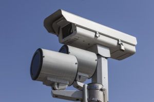 Stop light traffic camera with mounted strobe lights.